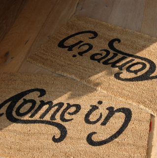 quirky door mat with the words come in / Go away printed within the 