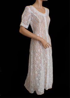 This 80s white sheer lace dress is tea length with glass buttons up 