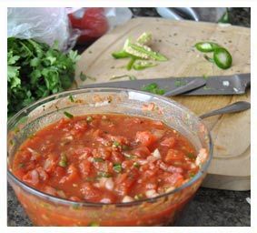 of cilantro garlic serrano peppers onions and tomatoes add garlic salt 