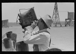 Day laborer drinking from desert water bag,large farm near Ralls,Texas